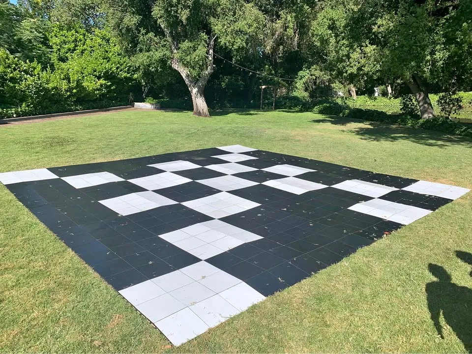 Pista de baile de cuadros blanco y negro sobre el pasto