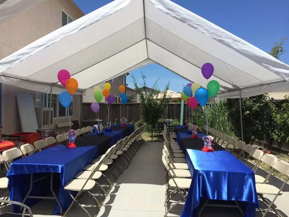 Carpa blanca con mesas decoradas en azul y globos